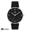 Minimalist wristwatch with a black dial, silver case, and black leather strap.