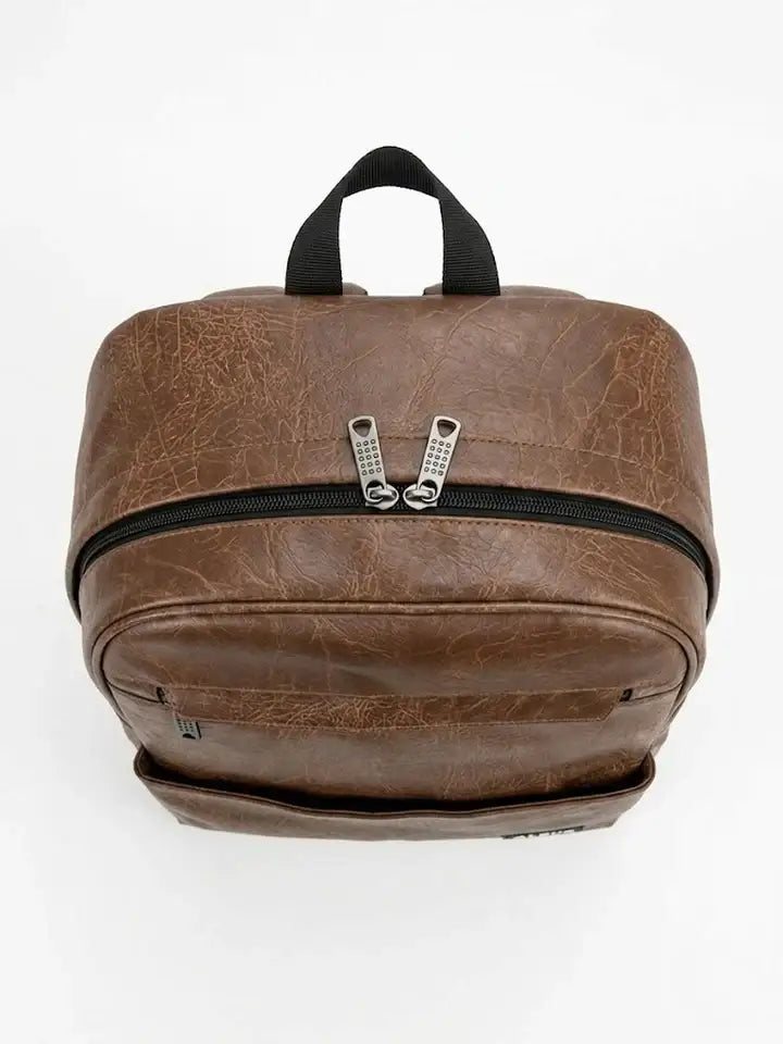 Brown faux leather backpack with a top handle and dual zipper closure.